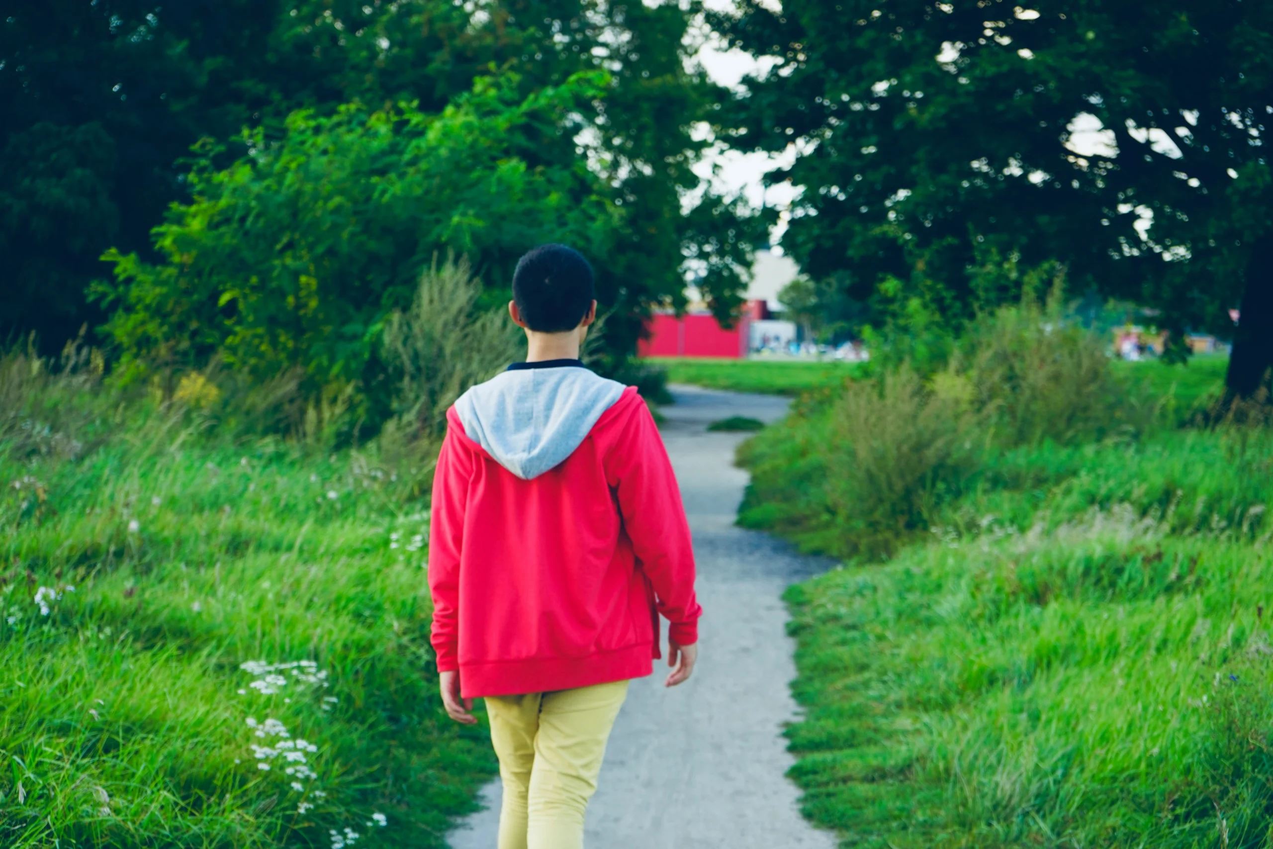 Adolescente caminhando sozinho por uma trilha