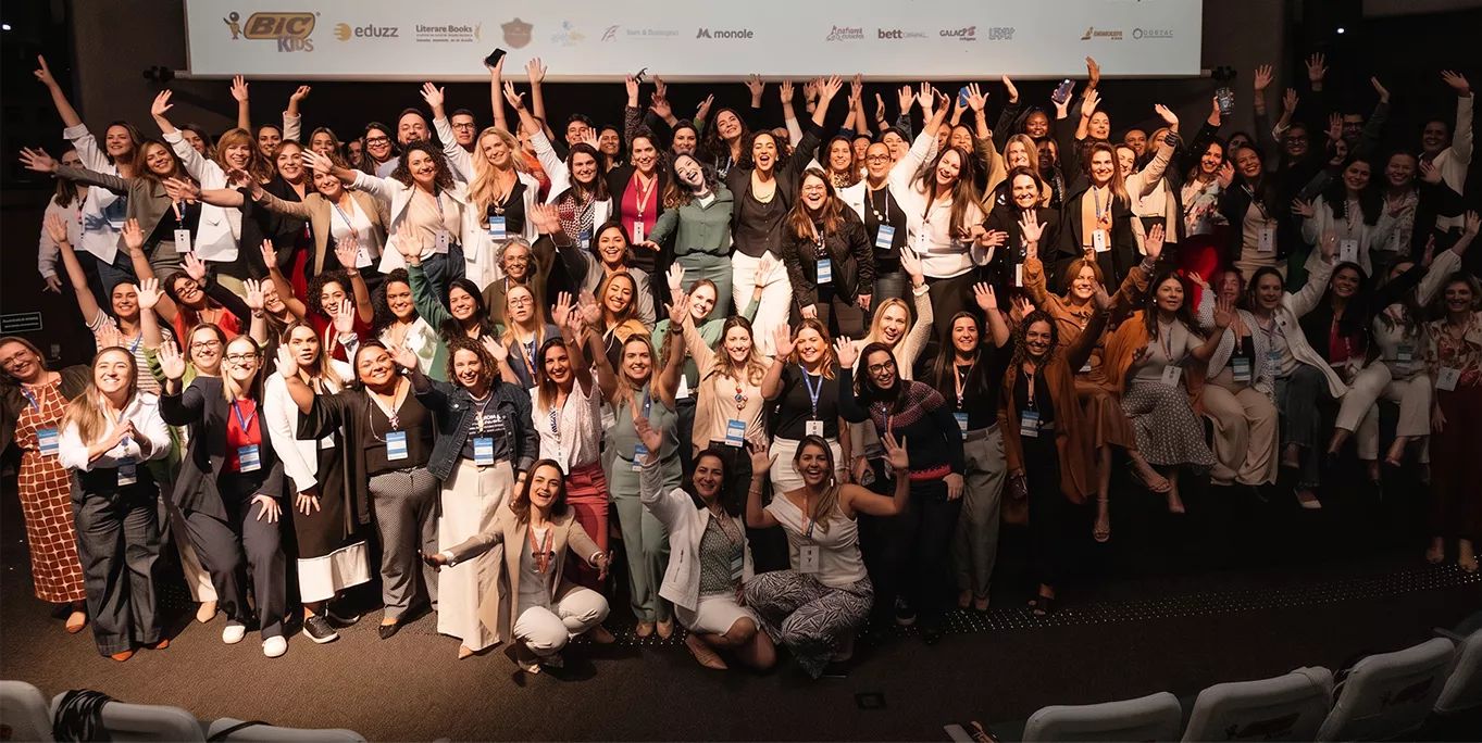 Turma da Academia Parent Brasil reunida no palco do congresso, de braços erguidos