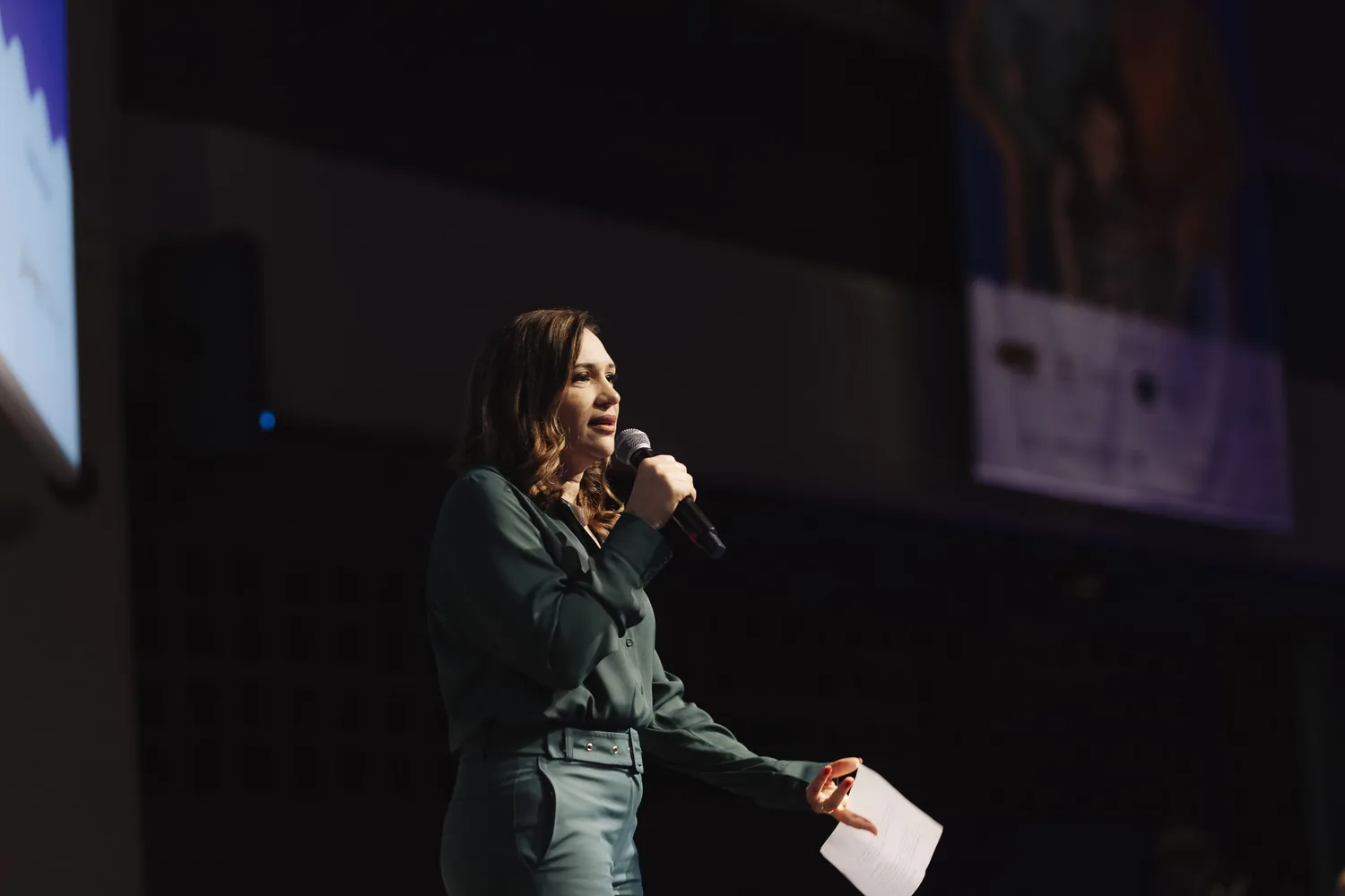 Jacqueline Vilela palestrando no palco de um evento de educação parental